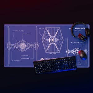 Könnte beinhalten: Blaues Gaming-Mauspad mit einem TIE-Fighter-Blaupaun-Design, einer schwarzen Tastatur, einer Maus und Kopfhörern. Das Design ist weiß, mit dem Text "YINO" auf dem Mauspad und der Tastatur.