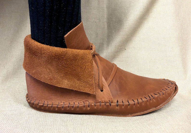 Peut inclure: Bottines en cuir marron avec un revers en daim et une couture d&eacute;corative autour de la semelle.