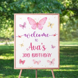 May include: Welcome to Ava's 3rd Birthday sign with a pink butterfly and gold glitter on a white background.