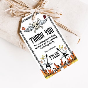 May include: A white thank you tag with a skull and crossbones with wings, guitars, and flames. The text reads "Thank you for coming and rolling with me on my rocking birthday party. You rock! Love, Tyler."