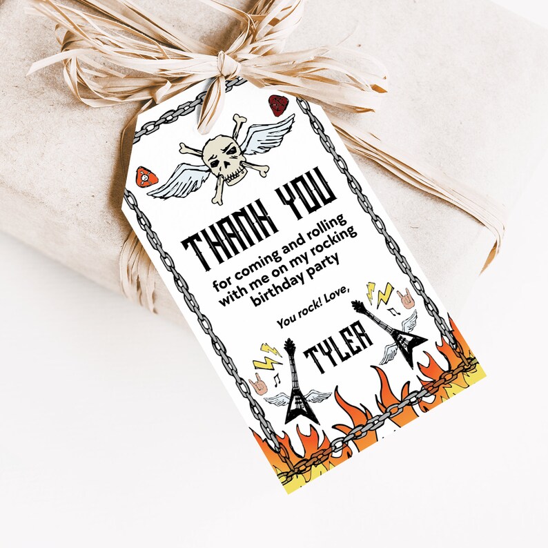 May include: A white thank you tag with a skull and crossbones with wings, guitars, and flames. The text reads "Thank you for coming and rolling with me on my rocking birthday party. You rock! Love, Tyler."