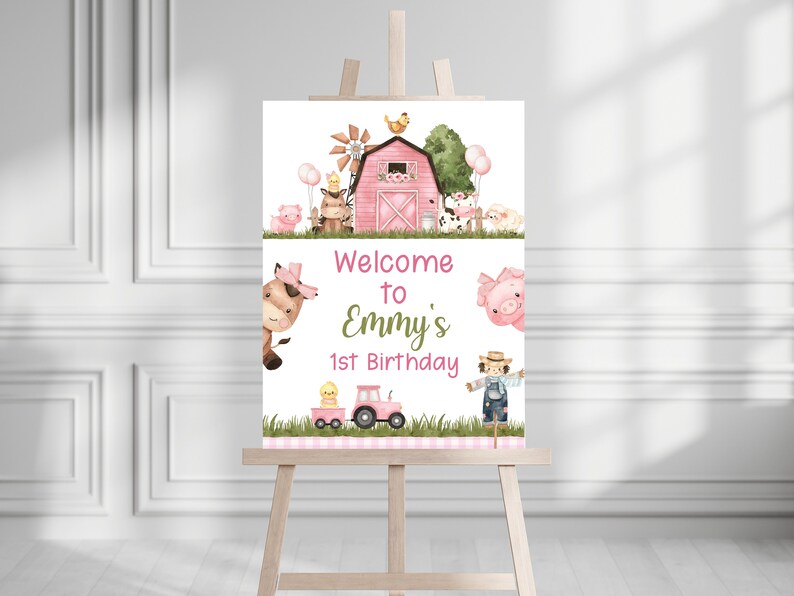 May include: Welcome to Emmy's 1st Birthday sign with a pink barn, farm animals, and a tractor. The sign is on a white background with green grass and pink and white checkered accents.