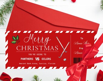 May include: A red Christmas card with the words "Merry Christmas" and "You're going to Panthers vs Oilers" printed on it. The card includes hockey sticks and a hockey puck graphic. The card is inside a red envelope.