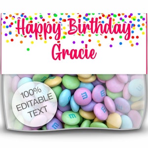 May include: A white favor bag with a pink banner that says "Happy Birthday Gracie" with colorful confetti. The bag is filled with pastel-colored M&M's candies. A white circle with the text "100% Editable Text" is visible in the lower left corner.