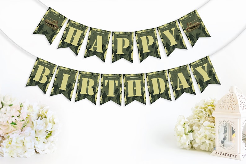May include: A green and tan camouflage patterned banner with the words "Happy Birthday" in yellow letters. The banner has small tank images on each end.