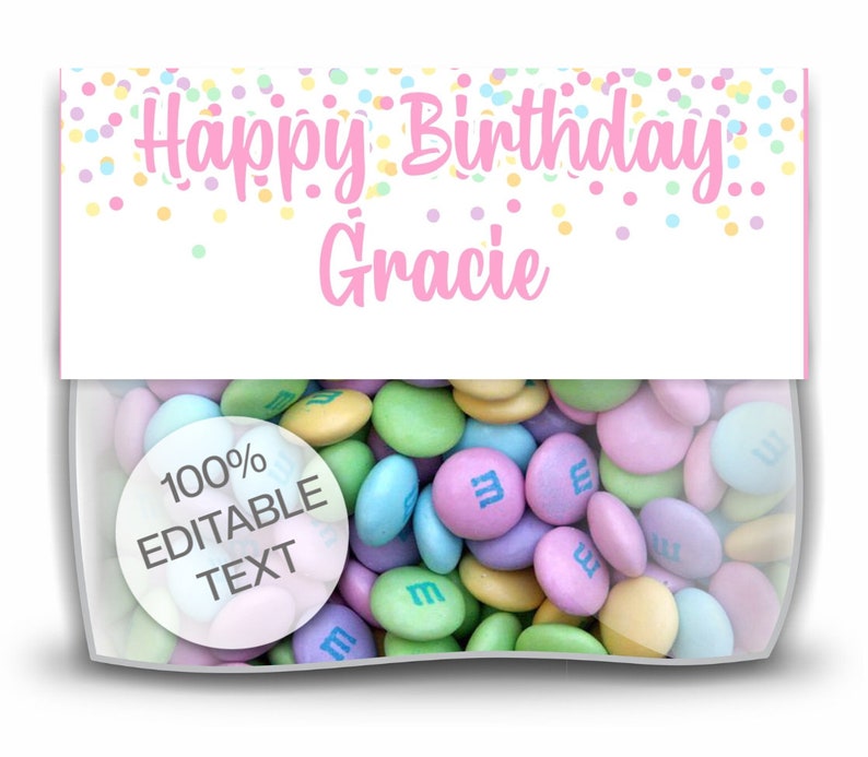 Op de afbeelding: Een doorzichtige cellofaan zak gevuld met pastelkleurige snoepjes. De zak heeft een wit label met "Happy Birthday Gracie" in roze letters, met kleurrijke confetti. Een ronde sticker zegt "100% Bewerkbare tekst".