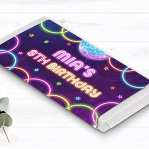 Puede incluir: Envoltorio de barra de caramelo con fondo morado y c&iacute;rculos y estrellas de color ne&oacute;n. El texto "MIA'S 8TH BIRTHDAY" se muestra en rosa y naranja ne&oacute;n. Tambi&eacute;n hay un gr&aacute;fico de bola de discoteca.