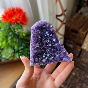 May include: A large amethyst crystal cluster with a purple hue and a natural, rough surface. The crystal is shaped like a heart and has many points.