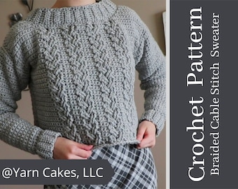May include: A grey crochet sweater with a braided cable stitch pattern. The sweater has a round neckline and long sleeves. The text "Crochet Pattern" and "Braided Cable Stitch Sweater" is on the right side of the image. The text "@Yarn Cakes, LLC" is at the bottom of the image.
