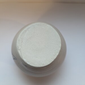May include: White ceramic vase with a blue and white floral design. The vase has a round body and a wide opening.
