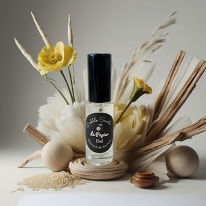 May include: A small glass bottle of perfume with a black cap and label. The label reads "Dabble Scents Le Papier 15ml Extrait de Parfum". The bottle is surrounded by dried flowers and wooden decor.