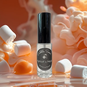 May include: A clear glass perfume bottle with a black cap, labeled "Apricot x Mallo" by Debble Scents. The bottle is surrounded by marshmallows and an orange-colored substance, set against a blurred orange background.
