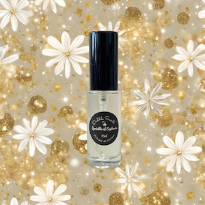 May include: A clear glass bottle with a black cap and a white label that reads "Dible Scent Sprinkle of Euphoria 15ml Extrait de Parfum".