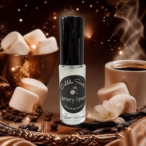 May include: A clear glass rollerball perfume bottle with a black cap and a circular black label. The label features the text Dabble Scents, an illustration of a perfume atomizer, and the words Glittery Opium Extrait de Parfum in white.