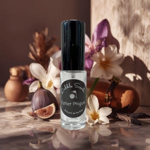 May include: A clear glass perfume bottle with a black cap, labeled "Dabble Scents Father Phigure Extrait de Parfum." The bottle is surrounded by white and purple flowers, a fig, and other decorative elements. The background is a warm, neutral tone.