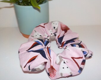 May include: Pink fabric scrunchie with a white dog and floral print.