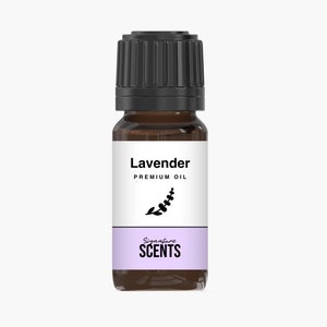 May include: A small brown glass bottle of lavender premium oil with a black cap. The label reads "Lavender PREMIUM OIL" with a sprig illustration and "Signature SCENTS" in a lavender band.