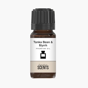 May include: A small, brown glass bottle of premium oil with a black cap. The label reads "Tonka Bean & Myrrh" and "Premium Oil" with a graphic of a bottle. The bottom of the label says "Signature SCENTS".