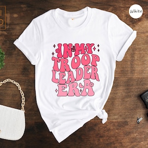 a white t - shirt with pink writing on it