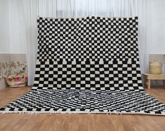 May include: Black and white checkered Moroccan rug with a thick, fluffy texture. The rug is laid out on a wooden floor.