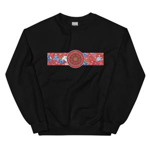 May include: Black sweatshirt with a red and white floral design. The design features a red rose emblem in the center, surrounded by a red and white floral pattern. The sweatshirt is made of a soft material.