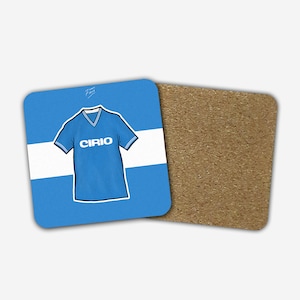 Könnte beinhalten: Ein blauer und weißer Untersetzer mit einem blauen Fußballtrikot mit dem Wort "CIRIO" auf der Vorderseite. Der Untersetzer ist aus Kork.