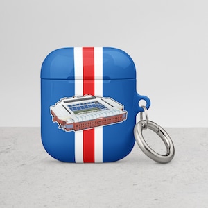 Könnte beinhalten: Ein blaues und weißes Airpods-Case mit einem roten Streifen und einer Grafik eines Stadions. Das Case hat einen silbernen Metall-Schlüsselanhänger.