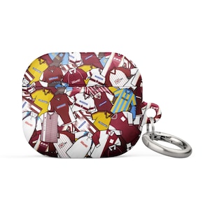 Puede incluir: Funda para AirPods con un diseño de camisetas de fútbol en varios colores, incluyendo granate, amarillo, blanco y azul. Incluye un lazo metálico plateado.