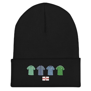 May include: Black knit beanie with embroidered images of four soccer jerseys and a Northern Ireland flag.