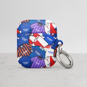 Könnte beinhalten: Eine blaue und weiße Handyhülle mit einem Muster aus Fußballtrikots mit dem Text "McEwans Lager". Die Hülle hat einen silbernen Ring.