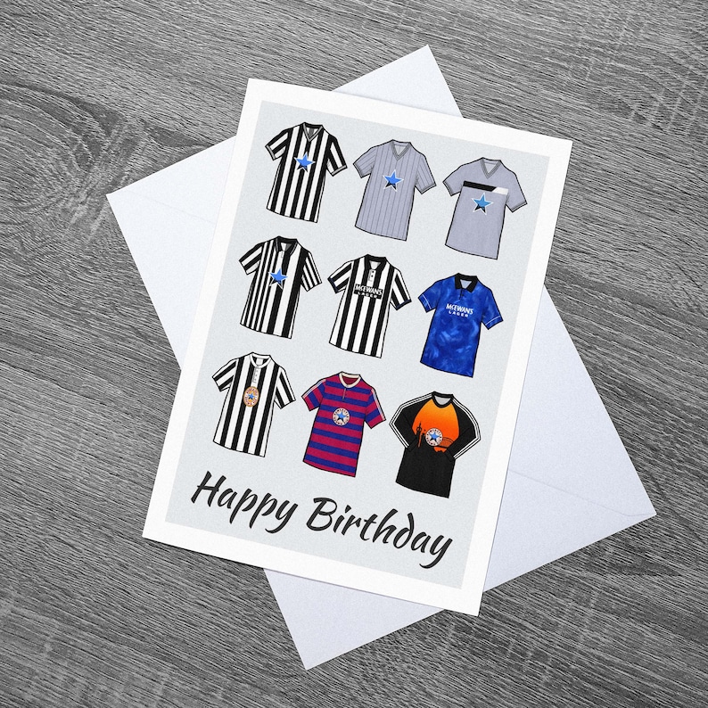 May include: A birthday card with a gray background featuring a collage of nine different soccer jerseys. The jerseys are in various colors and designs, including black and white stripes, blue and white stripes, and a blue jersey with a star. The text "Happy Birthday" is printed in black at the bottom of the card.