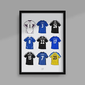 Peut inclure: Une impression encadrée de neuf maillots de football avec les noms et les numéros de joueurs célèbres de Chelsea, dont Cech, Terry, Lampard, Drogba et Hazard.