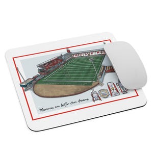 May include: White mousepad with a red border featuring a stadium illustration. The stadium has a green field and red seating. The text "ROVERS" is visible. The mousepad also has the text "Memories are better than dreams". A white mouse is next to the mousepad.