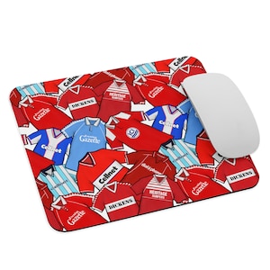Può includere: Un tappetino per mouse con un motivo ripetuto di maglie da calcio rosse, blu e bianche con vari loghi di sponsor, tra cui "Cellnet", "Dickens", "Evening Gazette", "Heritage Hampers" e "dial a phone".