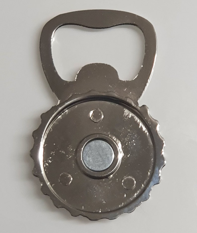 May include: Silver bottle opener with a magnetic back. The opener has a classic design and is perfect for opening bottles of beer or soda.