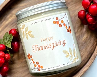 May include: A white candle with a silver lid and a label that says "LOGAN & CO CANDLES" and "Happy Thanksgiving". The label has a watercolor design of fall leaves and berries.