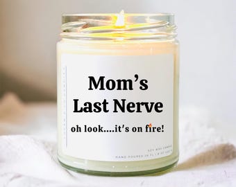 May include: A white soy wax candle in a glass jar with a black label that reads "Mom's Last Nerve oh look....it's on fire!"