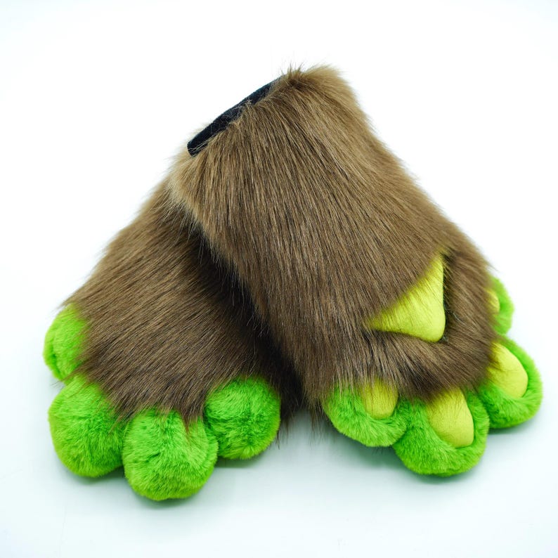 May include: A pair of brown furry slippers with green claws. The slippers are made of soft, plush fabric and have a realistic paw design.