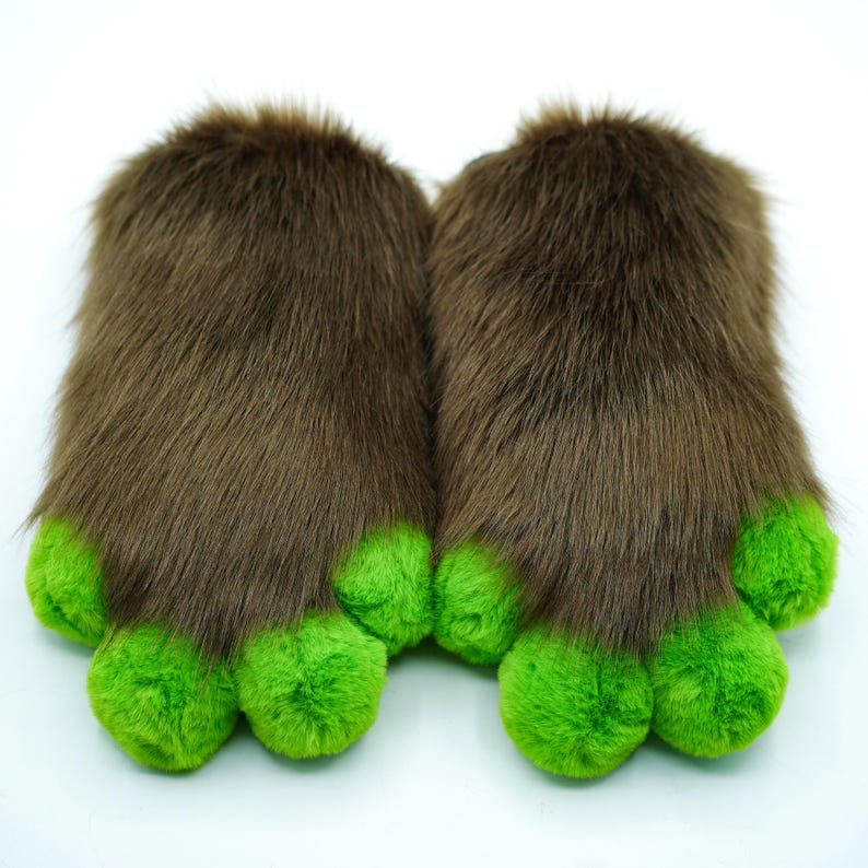 May include: A pair of brown furry slippers with green paw-shaped toes. The slippers are soft and plush, perfect for keeping your feet warm.
