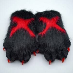 May include: A pair of black furry hand paws with red claws and red X markings on the back.
