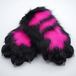 May include: A pair of black and pink furry paws with claws. The paws are made of soft, plush fabric and have a realistic look.