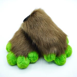 May include: A pair of brown furry hand paws with green claws. The paws are made of soft, plush fabric and are perfect for adding a touch of whimsy to any costume or cosplay.