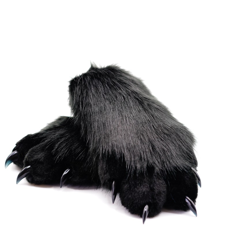 May include: A pair of black fuzzy slippers with black claws. The slippers are made of soft, plush fabric and have a realistic claw design.