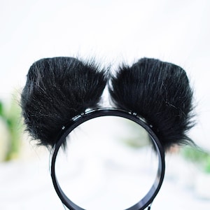 May include: Black furry headband with two large, fluffy, black ear-like pom-poms.