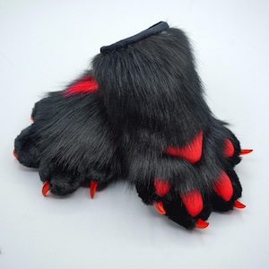 May include: A pair of black furry paw hand puppets with red claws and red accents on the paws.