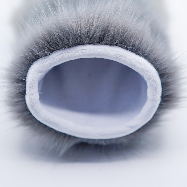 Puede incluir: Primer plano de un antiviento de micr&oacute;fono de piel gris con un forro interior blanco. El antiviento est&aacute; dise&ntilde;ado para reducir el ruido del viento al grabar audio.
