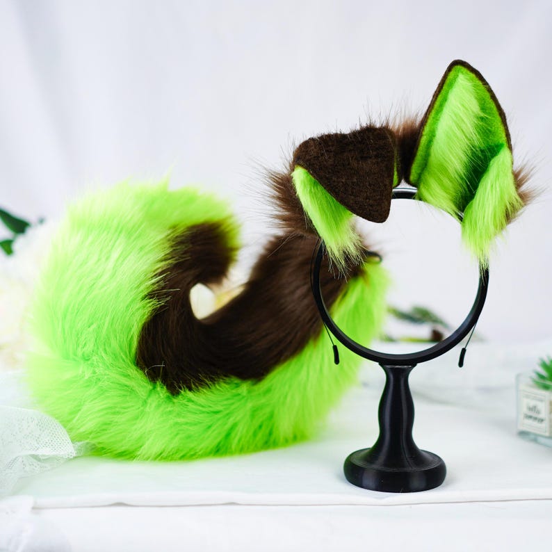Puede incluir: Un conjunto de accesorios de cosplay con una diadema y una cola, con piel sint&eacute;tica verde y marr&oacute;n. Las orejas de la diadema son verticales y la cola est&aacute; rizada. La diadema es negra. Los accesorios est&aacute;n dise&ntilde;ados para disfraces.