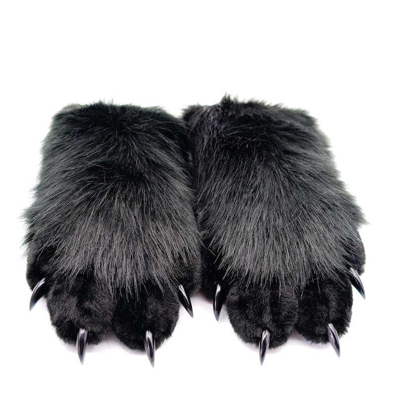 May include: A pair of black faux fur slippers with black claws. The slippers are soft and fluffy.