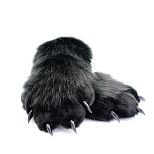 May include: A pair of black faux fur paw slippers with black claws.