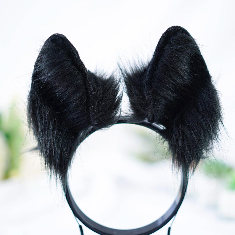 May include: Black furry cat ears headband. The headband is black and the ears are made of soft, fluffy black fur.